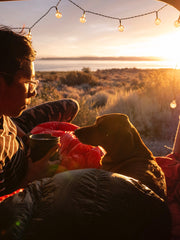 man and dog in tent overlooking a beautiful vista